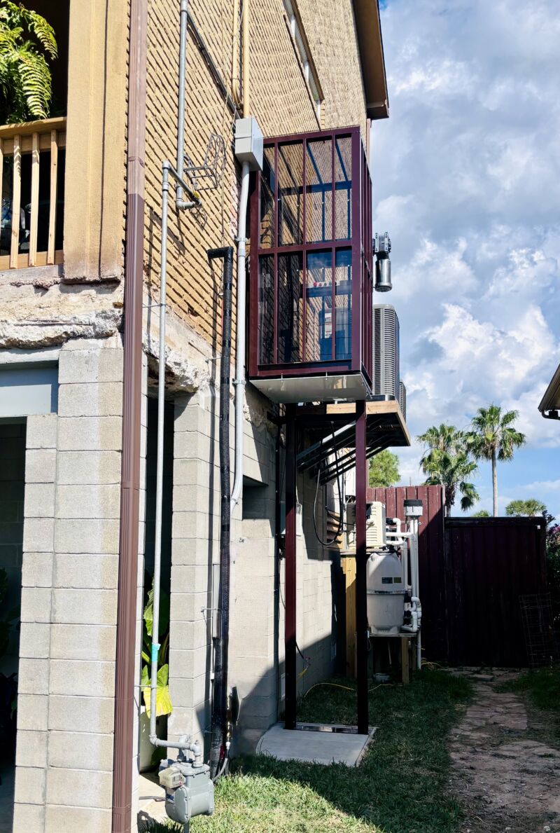 Explorer passenger lift installed alongside a brick building.